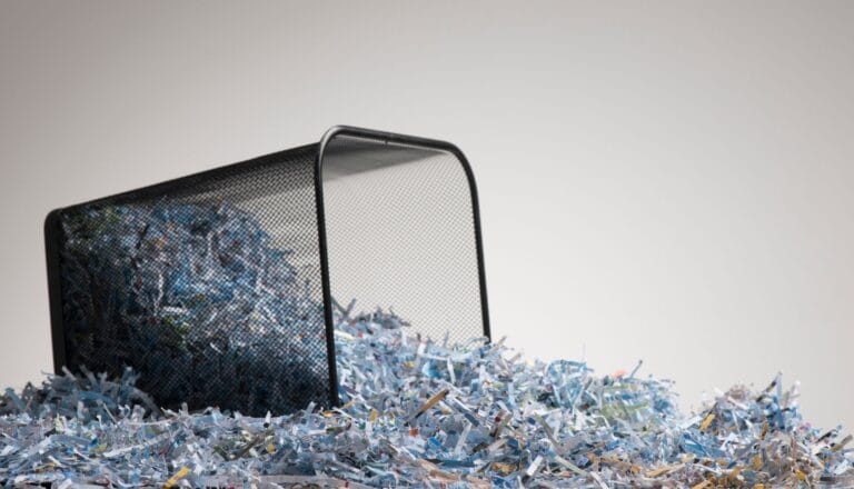 Overflowing trash bin with shredded paper